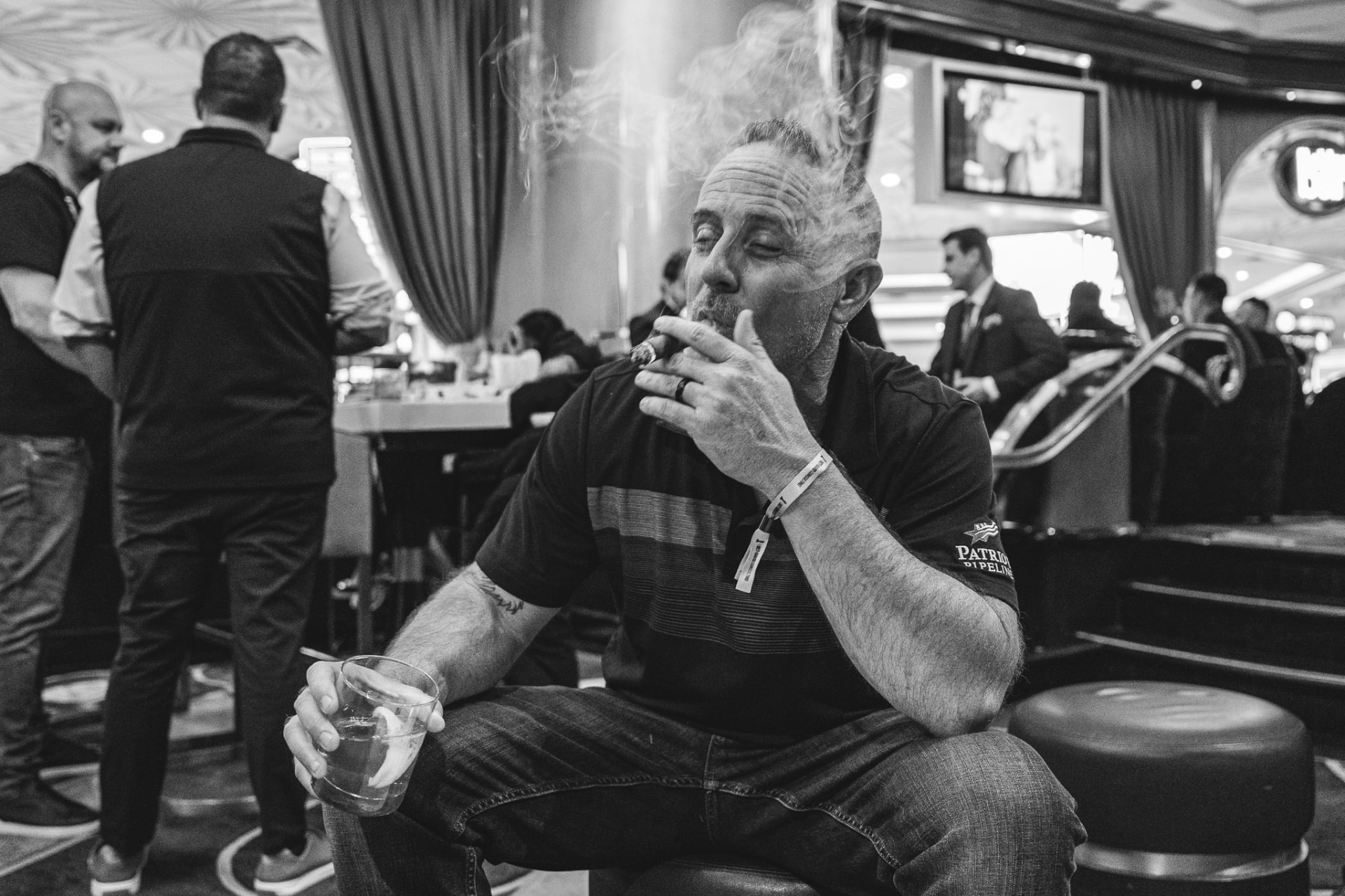 Jeff McClain seated with a cigar and a drink